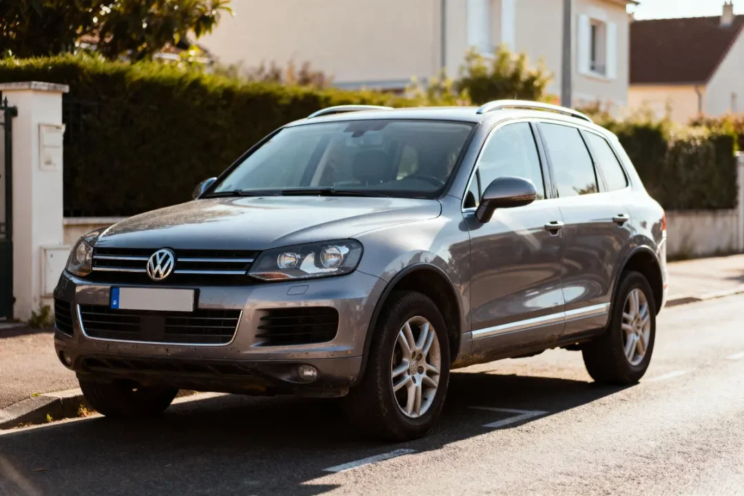 SUV gris Volkswagen garé sur une rue résidentielle, en plein jour, avec maisons en arrière-plan.