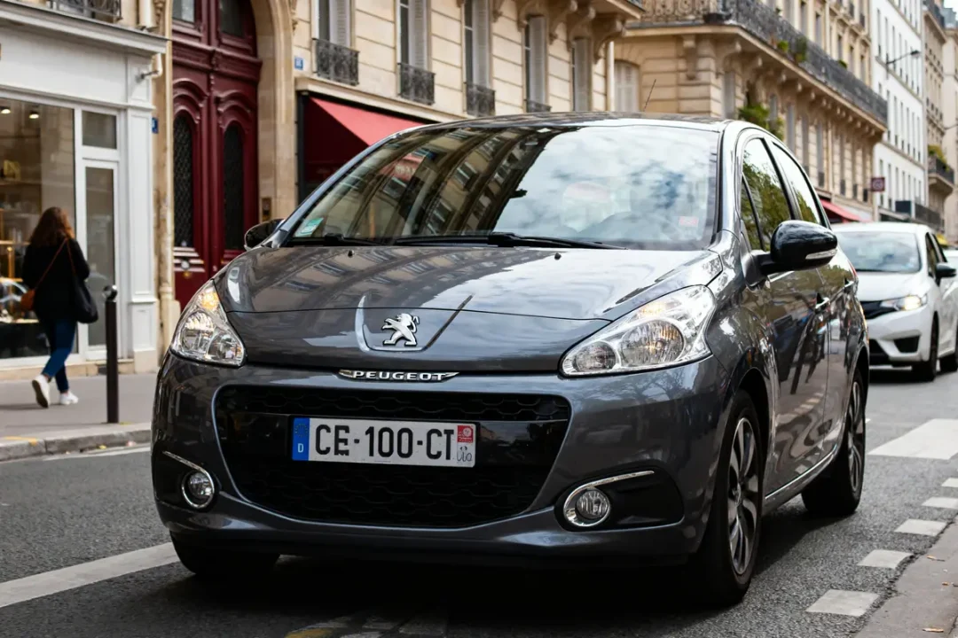 Voiture grise Peugeot 1008 garée sur une rue urbaine avec bâtiments historiques