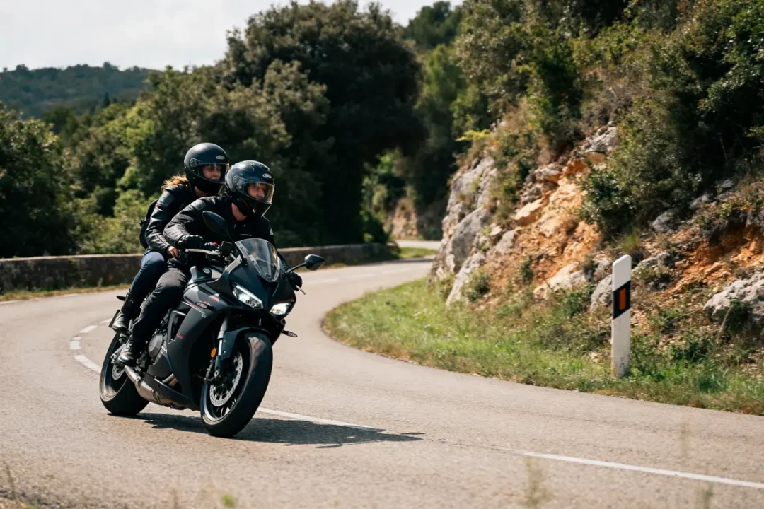 Deux motards en SDS moto noire sur route sinueuse entourée de verdure