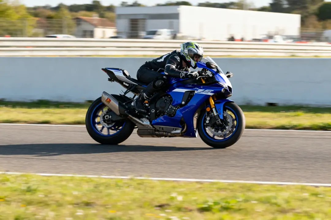 Pilote conduisant une Yamaha R1 vitesse max sur circuit pendant une journée ensoleillée