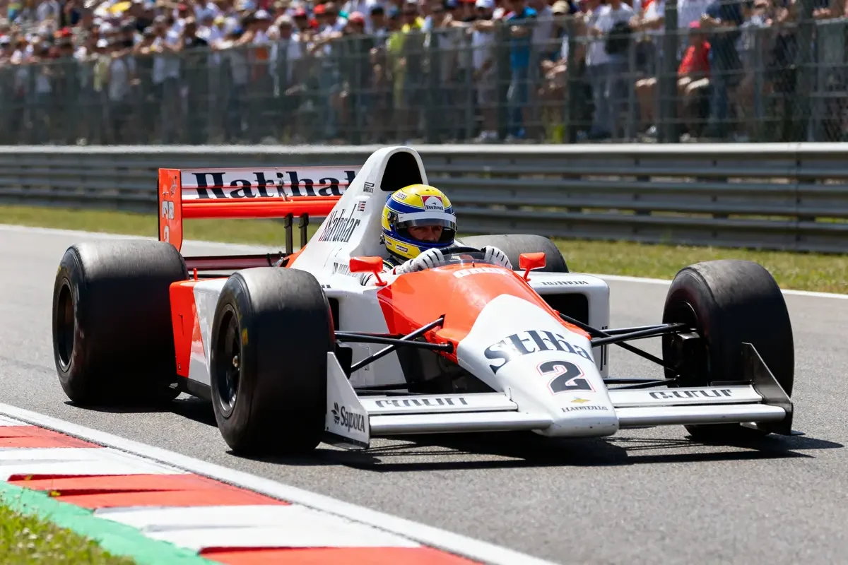 Voiture de course emblématique conduite par Alain Prost sur circuit pendant une compétition automobile