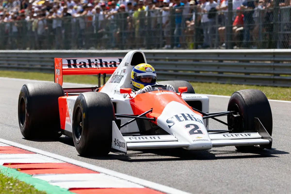 Voiture de course emblématique conduite par Alain Prost sur circuit pendant une compétition automobile