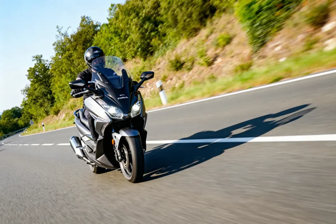 Pilote en Honda Forza 350 sur route, puissance et vitesse maximale en plein air