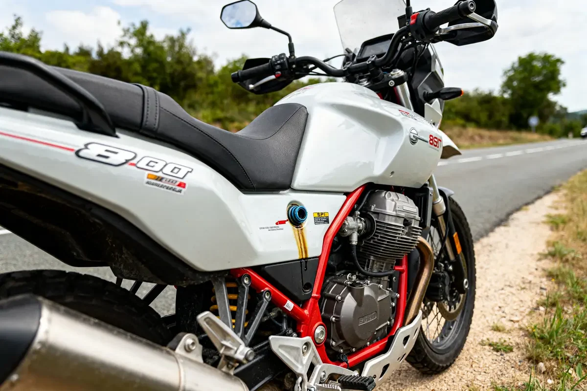 Moto Guzzi V85 TT avec fuite d'huile sur le carénage en bord de route