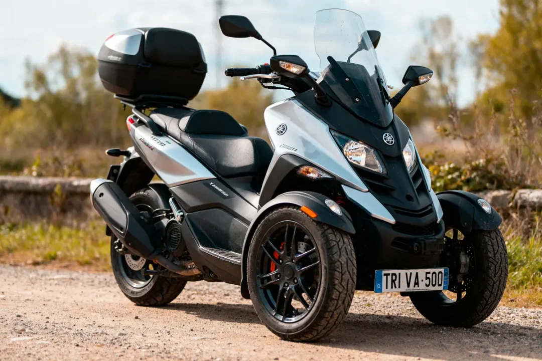 Scooter Yamaha Tricity 500 garé sur chemin, neuf, avec prix compétitif visible sur la plaque