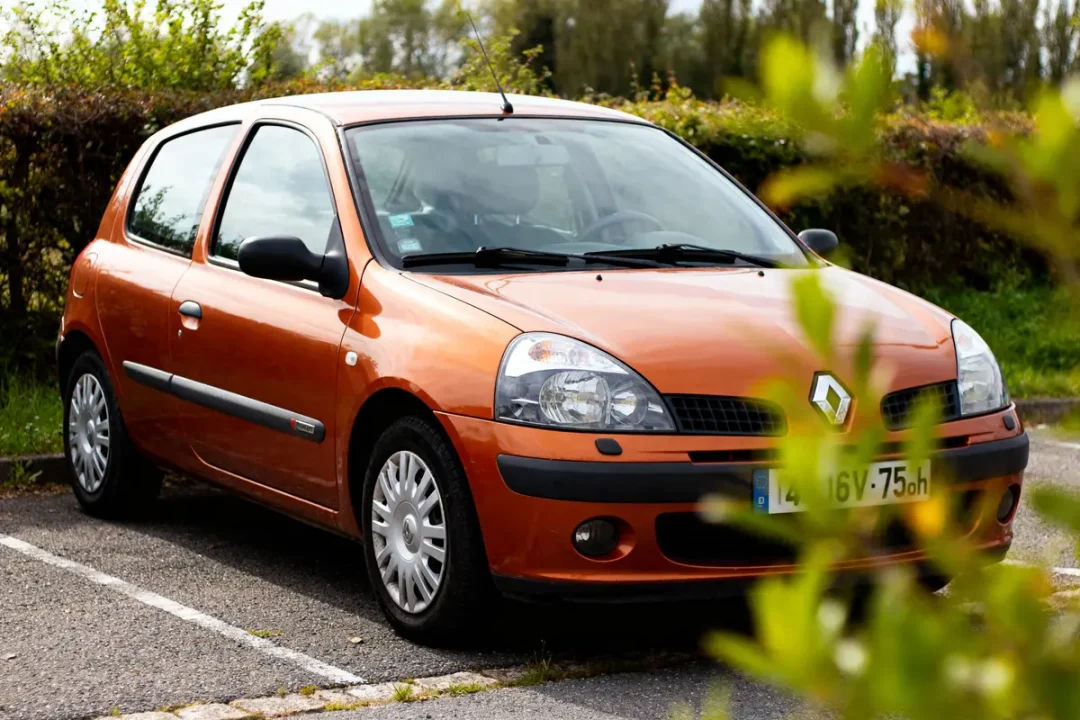 Voiture orange garée, illustrant la fiabilité de la Clio 3 1.2 16v 75ch