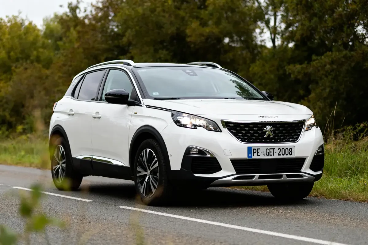 SUV Peugeot sur route, mettant en valeur les dimensions de la 2008 en extérieur naturel