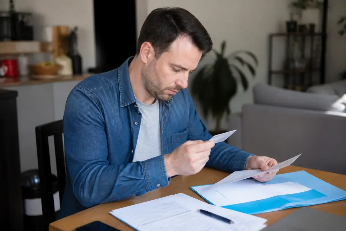 Homme lisant des documents sur pourquoi conserver son ancien permis de conduire