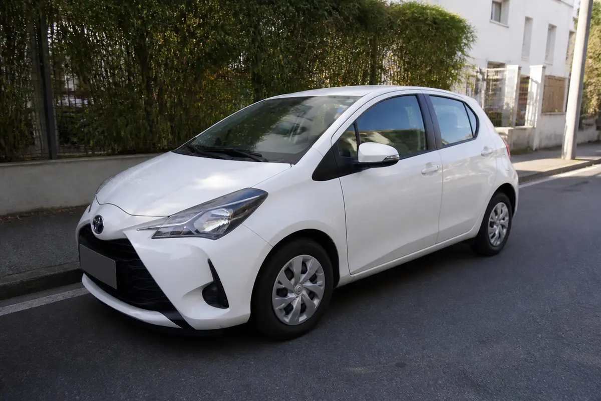 Toyota Yaris blanche garée, idéale pour vérifier la pression des pneus Toyota Yaris.