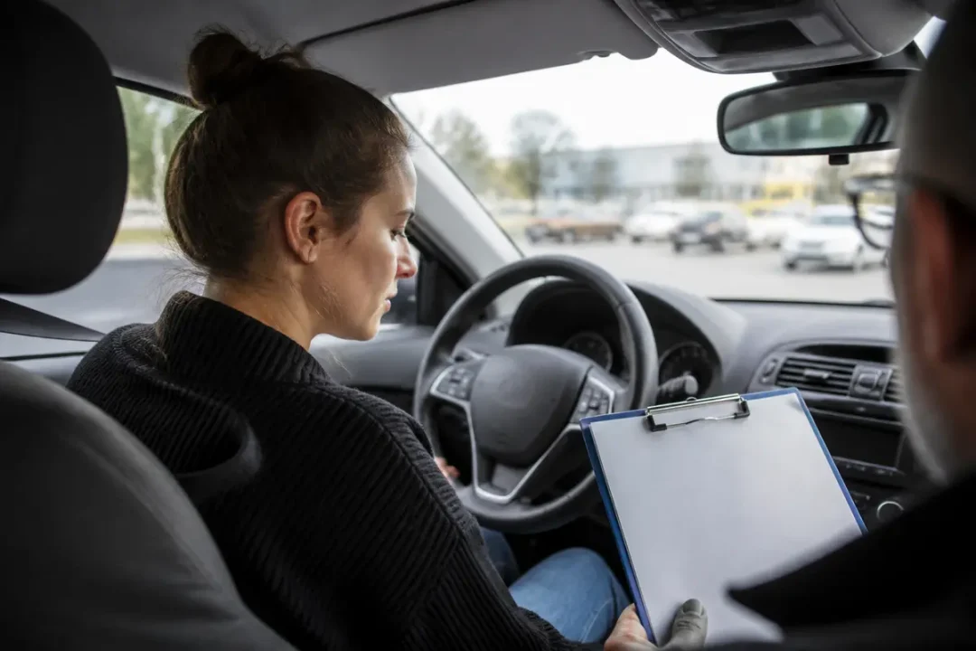 Femme au volant répondant à une question sur le permis d'un examinateur en voiture