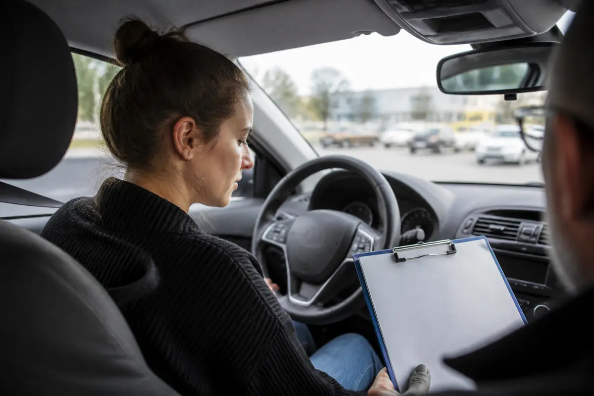 Femme au volant répondant à une question sur le permis d'un examinateur en voiture